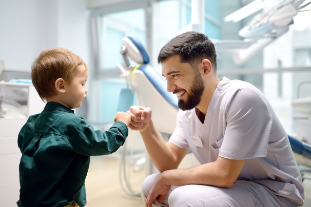 A little boy fist-bumping his dentist