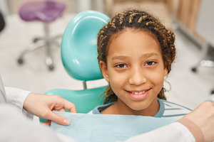 Child in dental chair getting ready for tooth extraction